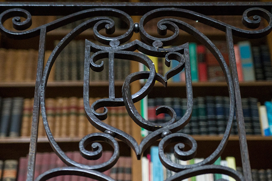 an iron bannister in Baker Library with the letters D and C worked in a fancy script