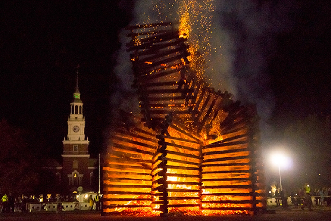 a bonfire burning with Baker Tower in the background