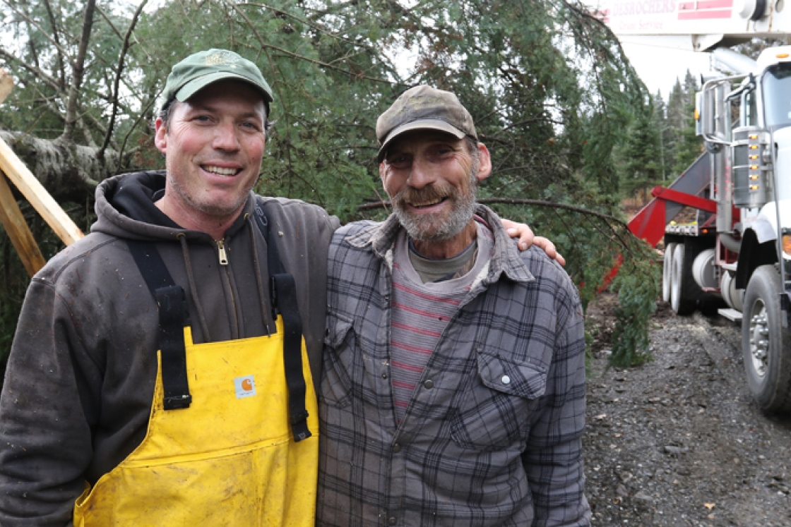 Vermont farmer Sage D'Aiello, left, and his father, Rich D'Aiello, pause during the harvesting of Dartmouth's holiday tree. CREDIT: Photo by Herb Swanson