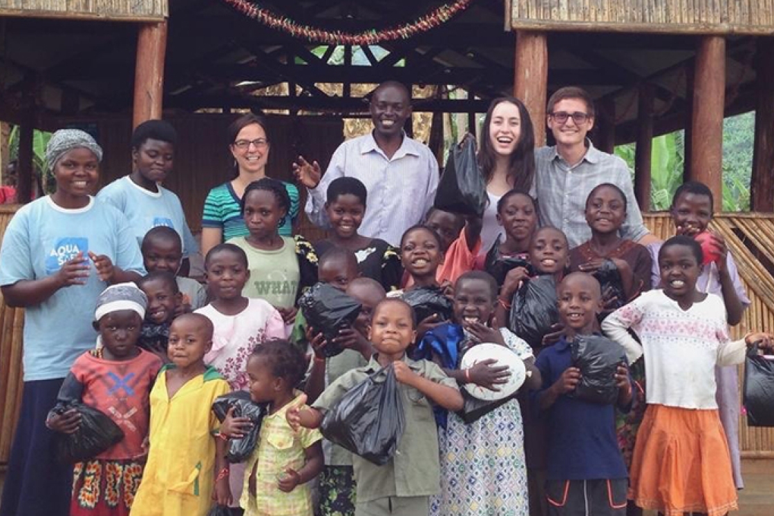 Sydney Kamen standing with a group of children in Uganda