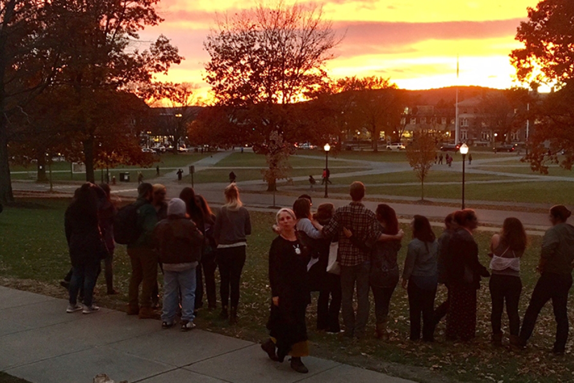 Pati Hernández standing with students and teaching assistants on the Green at sunset