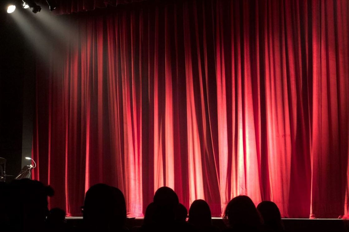 Red and black image of an audience in silhouette