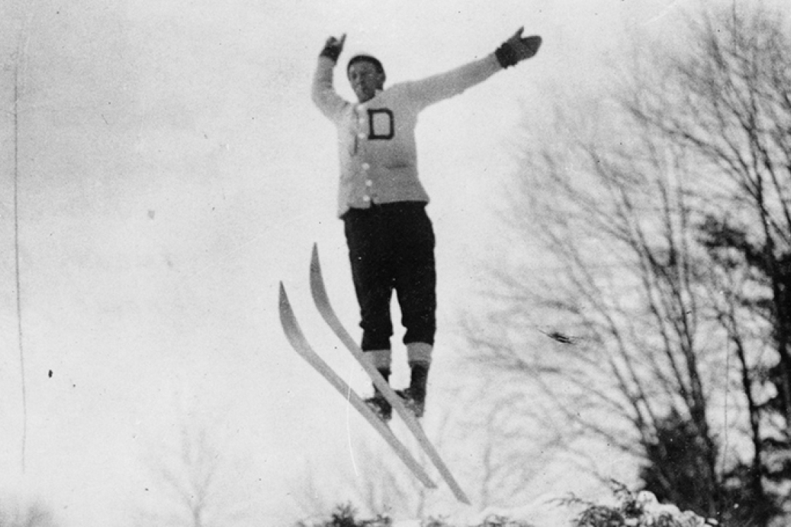 a black and white photo of a skier soaring through the air after a jump at the 1911 Winter Carnival
