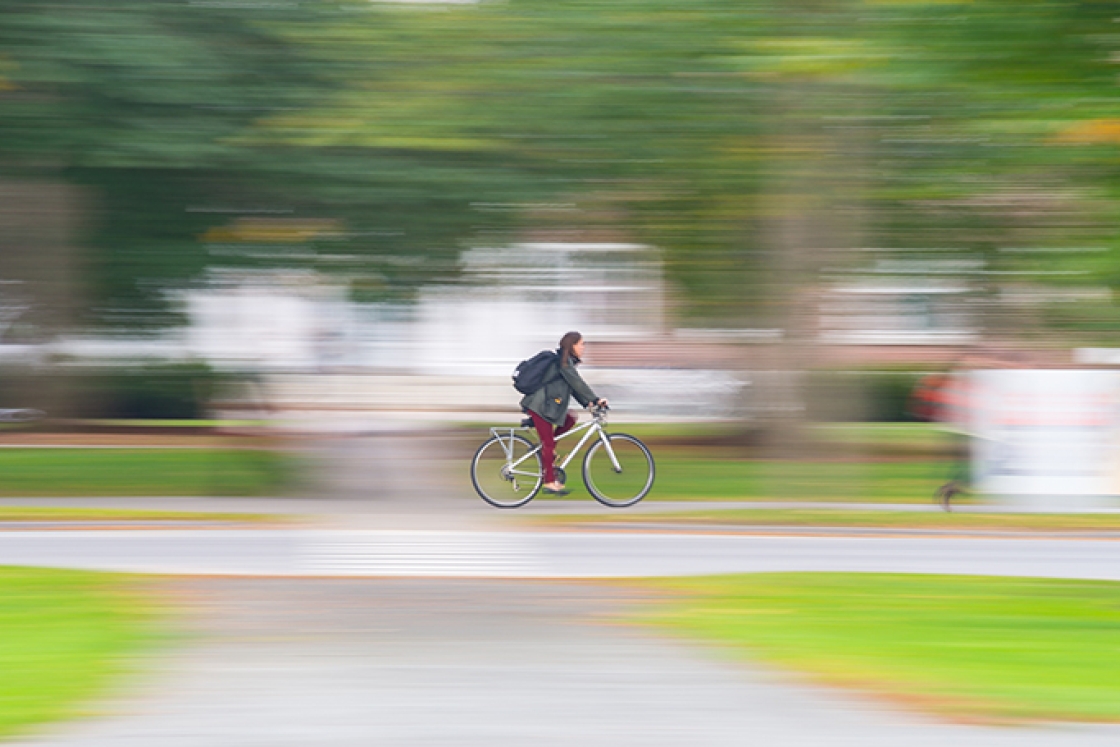 Dartmouth student rides a bike across campus.