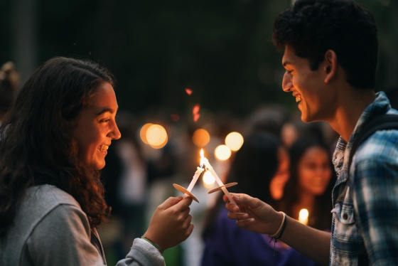 Two students lighting candles together