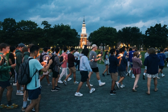 Students carry candles during the twilight ceremony