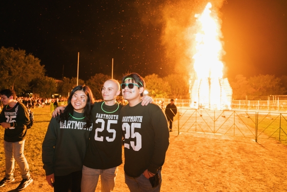 Members of the Class of '25 stand in front of the bonfire