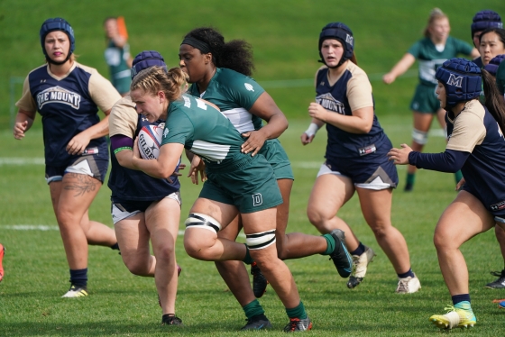 Women's rugby players running the ball