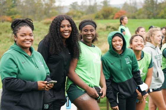 5 women's rugby players smiling for the camera