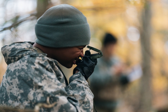 An ROTC cadet looks through a compass