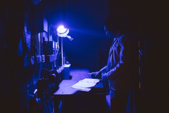 A person reading a script under black lights