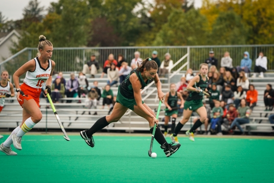 A Dartmouth field hockey player taking the ball down the field