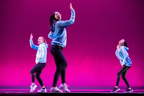 Members of dance troupe Street Soul performing against a pink background