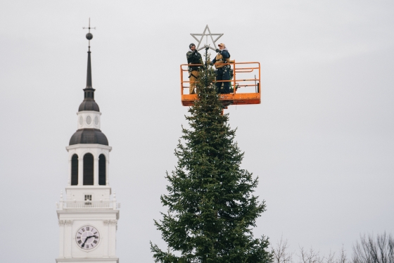 Baker tower and two people topping tree with a star