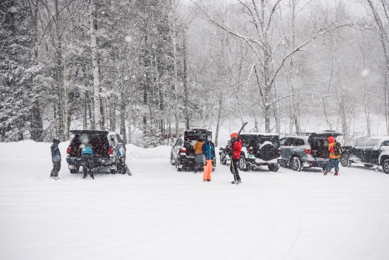 Skiers unloading ski equipment from their cars