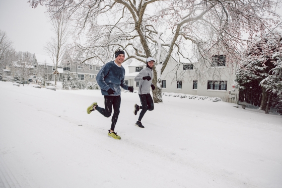 Two people running during a snowstorm