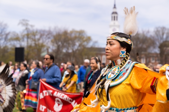 Woman dressed in yellow celebratory Native American clothing