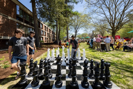 Three students play outdoor chess
