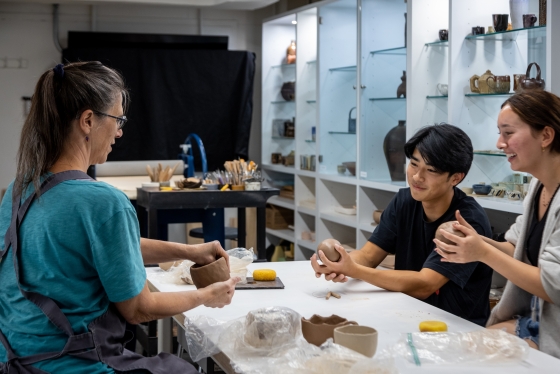 Instructor and students in the ceramics studio