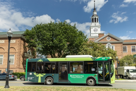 Green shuttle with D-pine logo in front of Baker Library