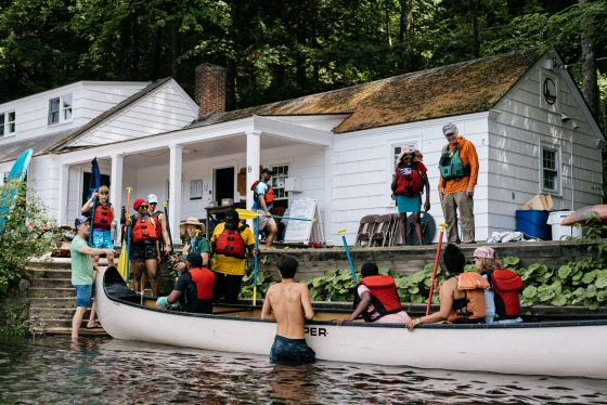 People getting in the canoe at the Ledyard Boat House