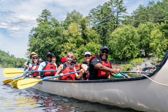A group of people smiling in a canoe