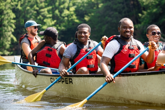 YALI students smiling and canoeing on the Connecticut River