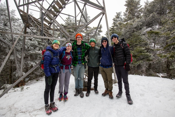 Students pose under the fire tower on Smarts Mountain