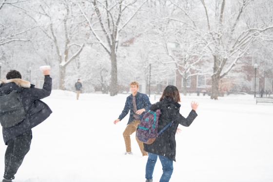 Students partake in a snowball fight on the Green