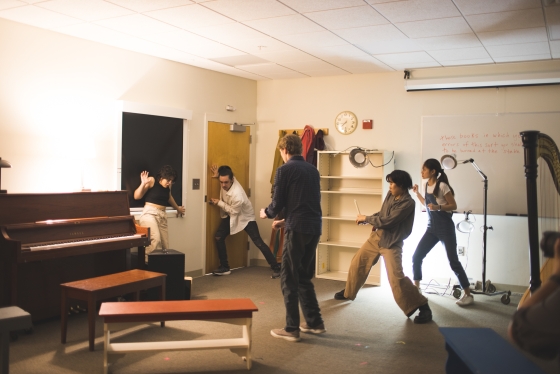 Students circled up acting in the corner of a room