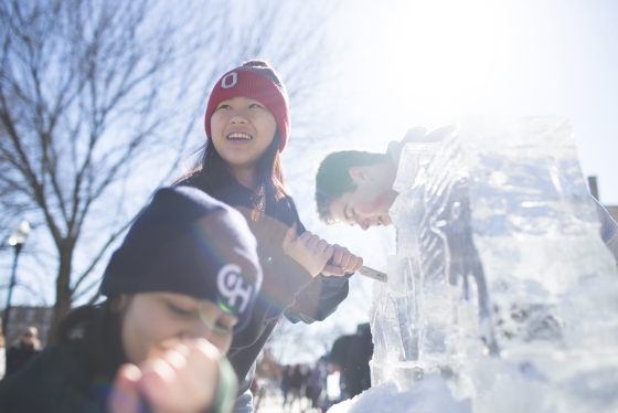 Students carve ice in the sunshine