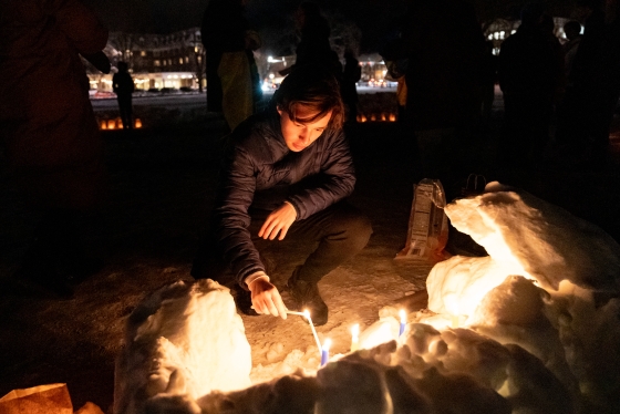 A student lights candles during the Ukraine vigil at Dartmouth College