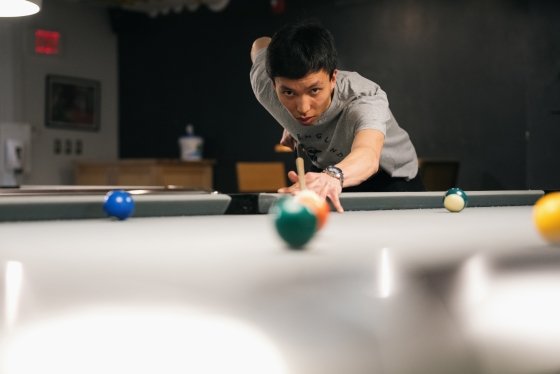 Michael Chan '23 lines up a pool shot in Collis.