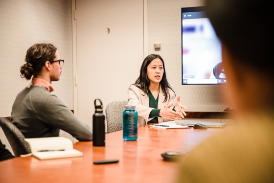 Mary Yang speaks with students in a board room