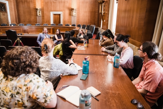 Students and staffers in a board room
