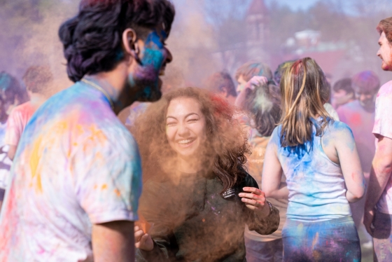 Students throw powdered color on each other during Holi