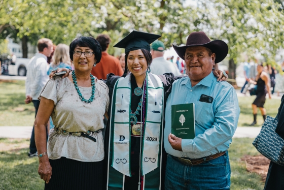 Student poses for a photo with parents at Dartmouth Commencement