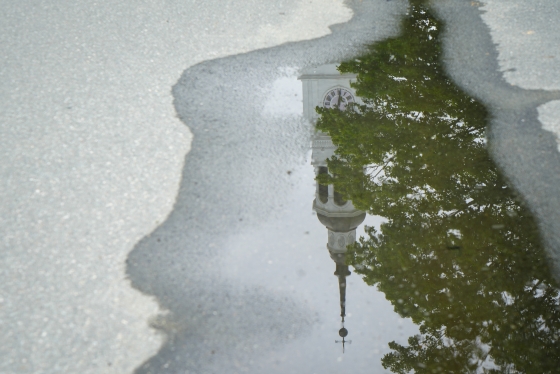 Reflection of Baker Tower in a sidewalk puddle
