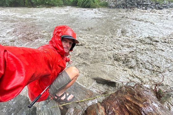 Jordan Fields, Guarini '21, gets sediment sample from flooding brook.