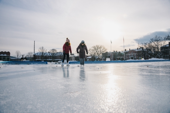Two women skate on Dartmouth Green ice rink