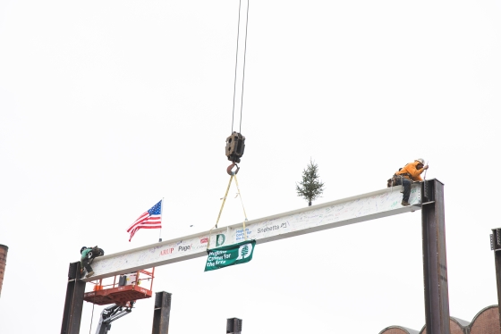 Construction workers secure the final steel beam