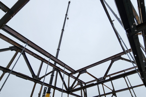 A crane framed by steel beams.