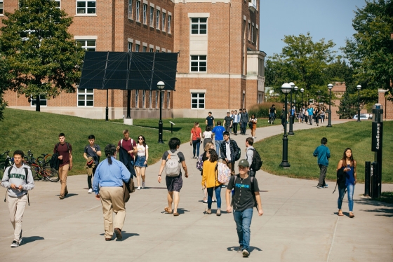 Students walk along the walkway between classes