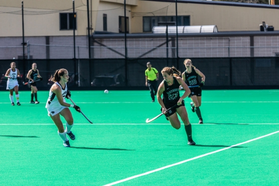 A field hockey player races after the ball