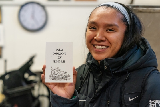 A student displays a card created in a class in the book arts studio