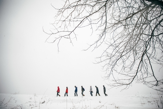 Seen from a distance, students walk across a snowy field