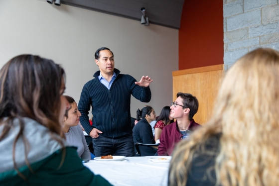 Julian Castro speaks at a table of students