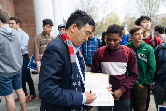 Andrew Yang signs a book for a student