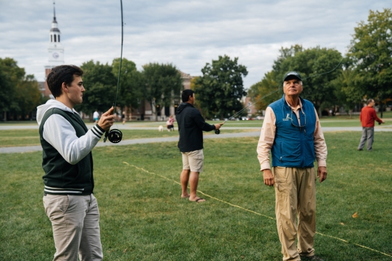 Andrew Hemelt '22 practices his cast under the watchful eye of Steve Rowe, who teaches a fly-fishing class on the Green.