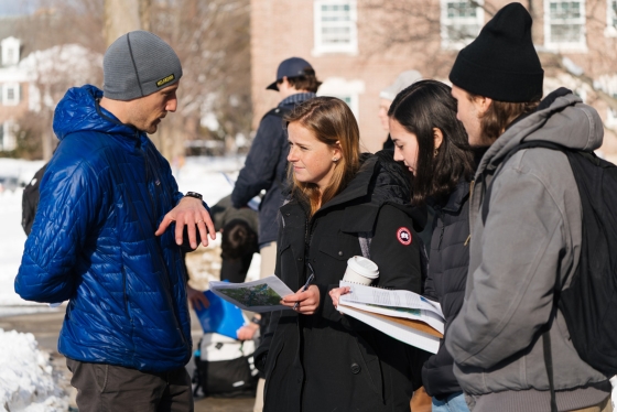 Assistant Professor of Earth Sciences Justin Strauss teaches Earth Sciences 002 outside. He is teaching three students how to read topographical maps.